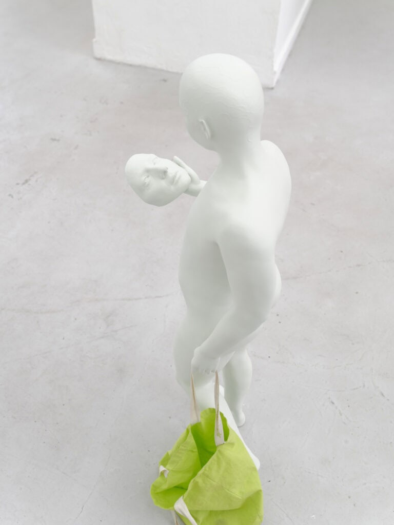 Foto: Nahaufnahme einer Skulptur vor hellgrauem Boden.