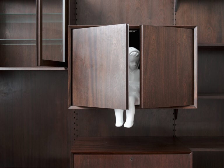 Foto: Nahaufnahme einer Konstruktion mit schrankartigen Elementen, in der sich ein helles Objekt befindet.