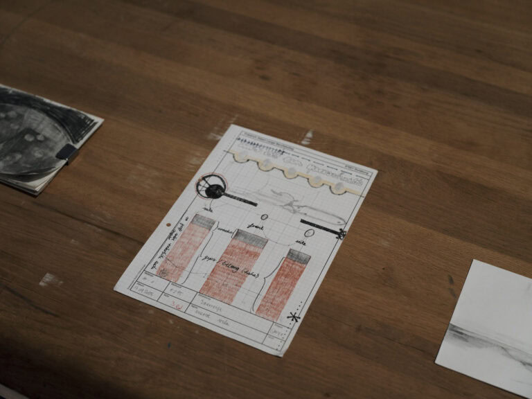 Foto: Nahaufnahme einer Platte, auf der Zeichnungen liegen.