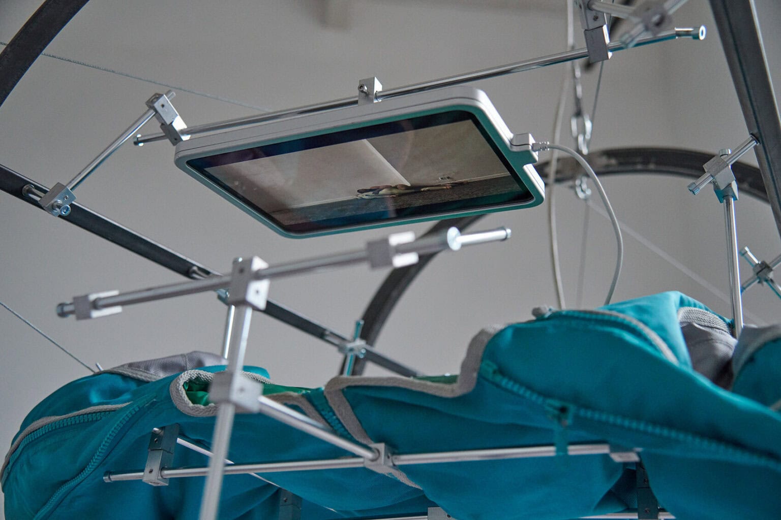 Foto: Detailaufnahme eines Objektes auf unterschiedlichen Materialien, darunter ein eingeschalteter Display.