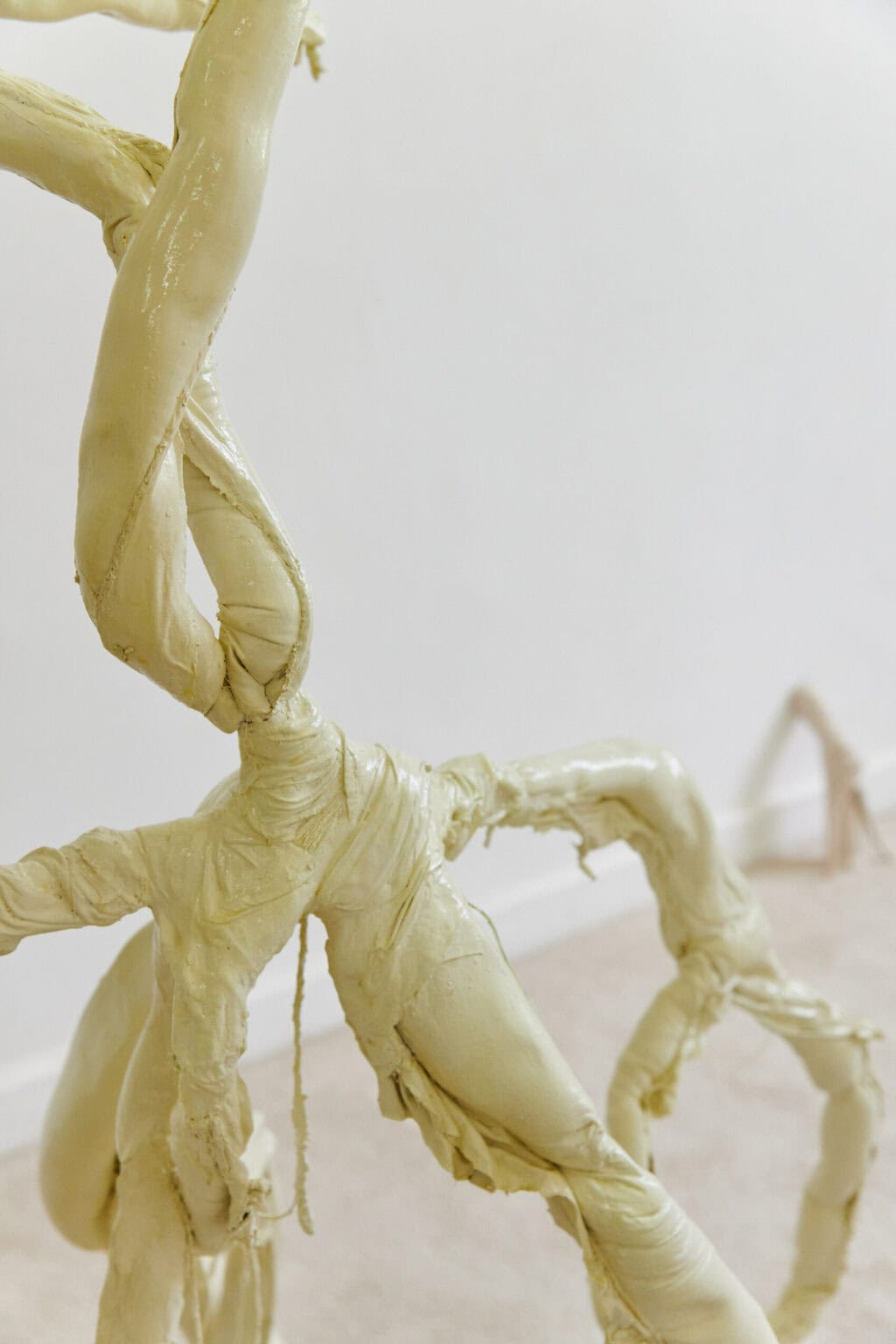 Foto: Detailaufnahme einer gewundenen, gelblichen Skulptur.