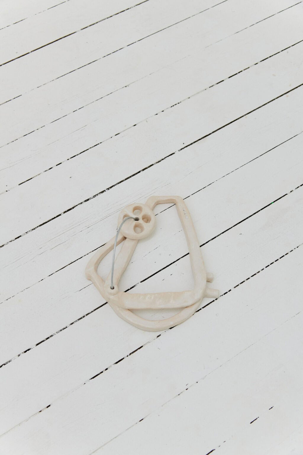 Foto: Ein Objekt, bestehend aus unterschiedlichen Materialien, auf weißem Dielenboden.