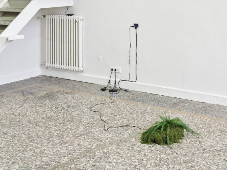 Foto: Foto: Ansicht eines Raumes mit weißen Wänden und einem mehrfarbigen Steinboden. An den Wänden und auf dem Boden befindet sich Objekte, die mit Kabeln miteinander und mit einer Steckdose verbunden sind.