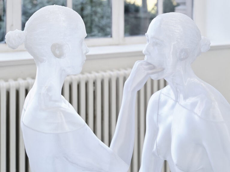 Foto: Nahaufnahme einer Skulptur vor einer Heizung und einem Fenster.