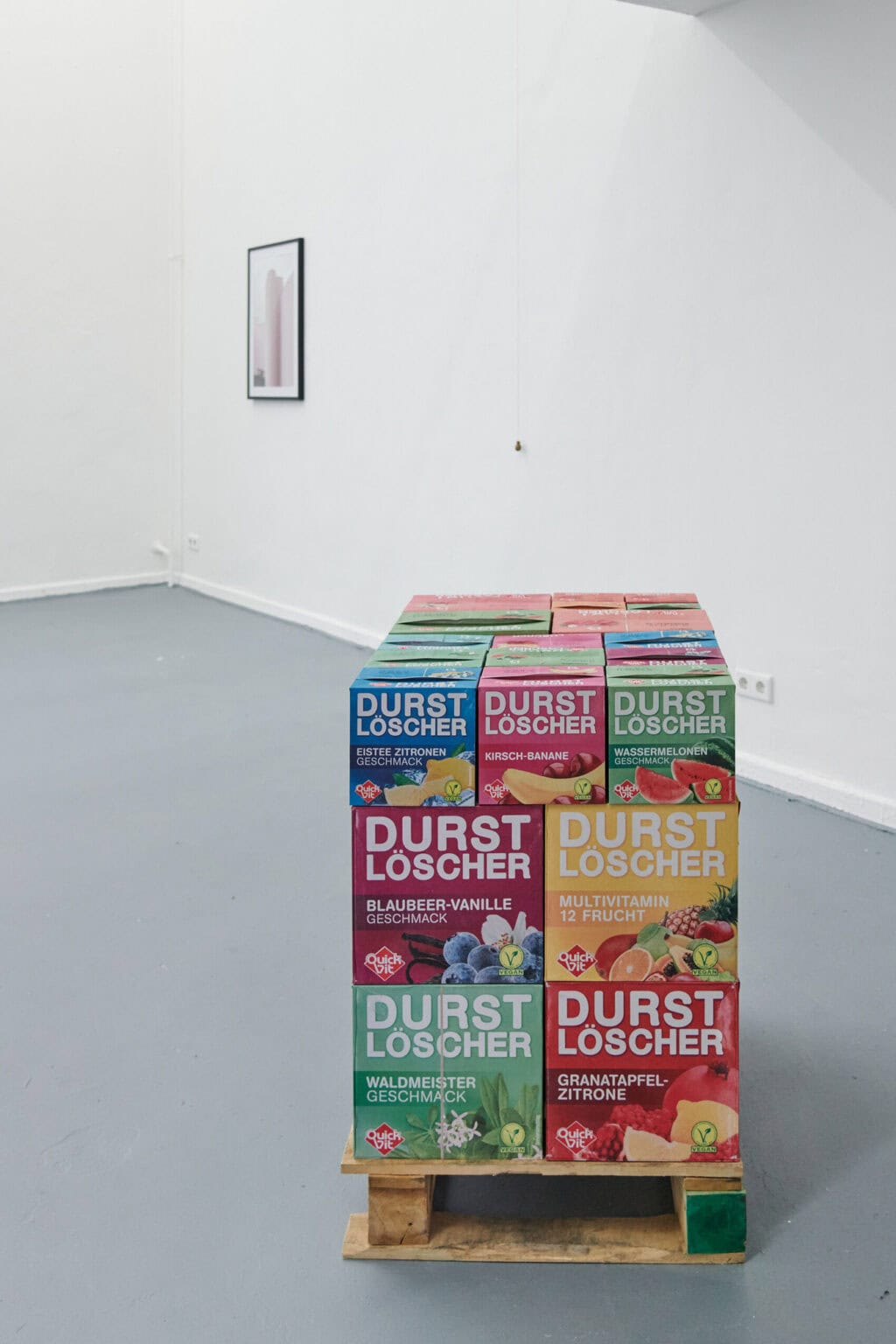 Foto: Ansicht eines Raumes mit weißen Wänden und grauem Boden. Auf dem Bogen steht ein Objekt, an der Wand hängt ein weiteres flaches Objekt.