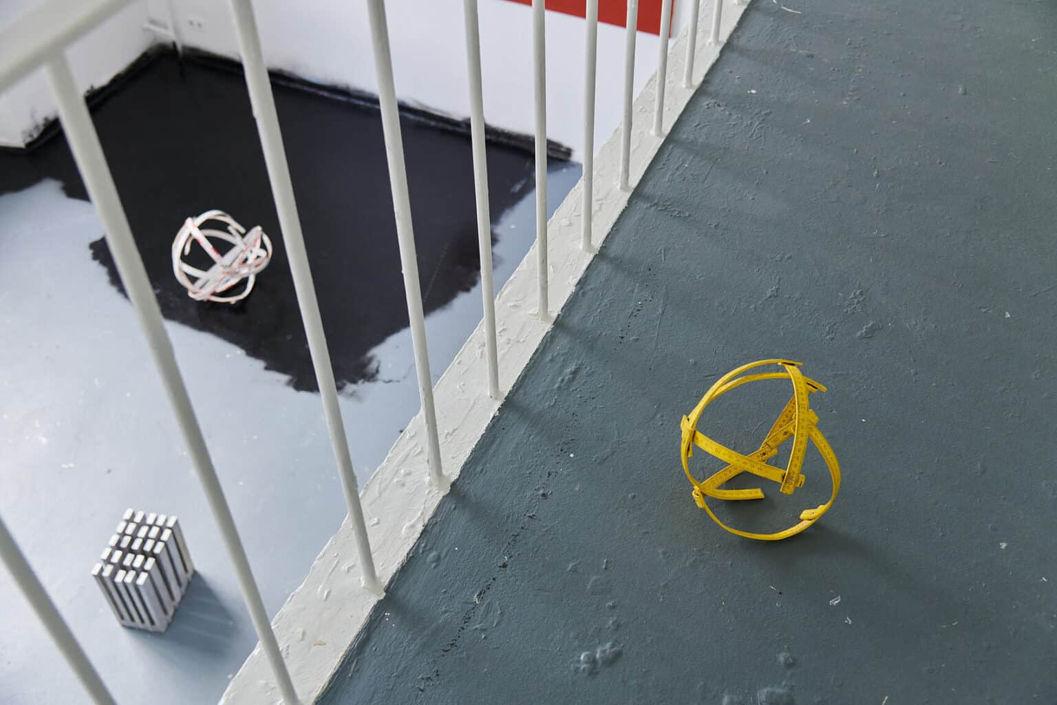 Foto: mehrere Objekte, die auf unterschiedlichen Ebenen im Raum auf dem Boden liegen.