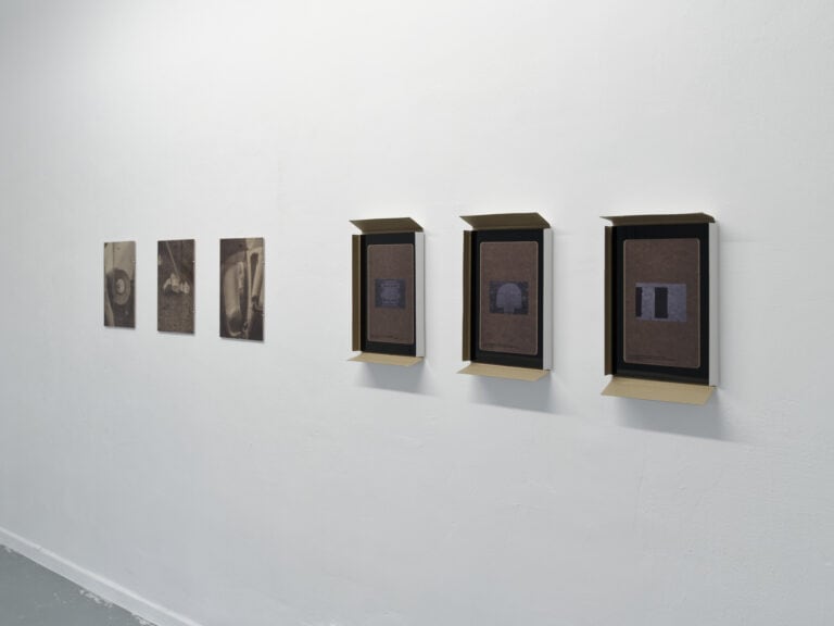 Foto: Ansicht einer weißen Wand, darauf sechs Objekte, auf gleicher Höhe gehangen.