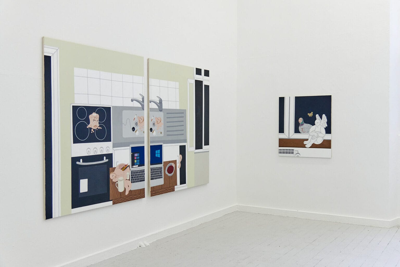 Foto: Eine Raumecke mit weißen Wänden und grauem Dielenboden. An der Wand hängen drei Leinwände im Mittel- und Kleinformat. Zwei der Leinwände hängen nah beieinander und verbinden sich.