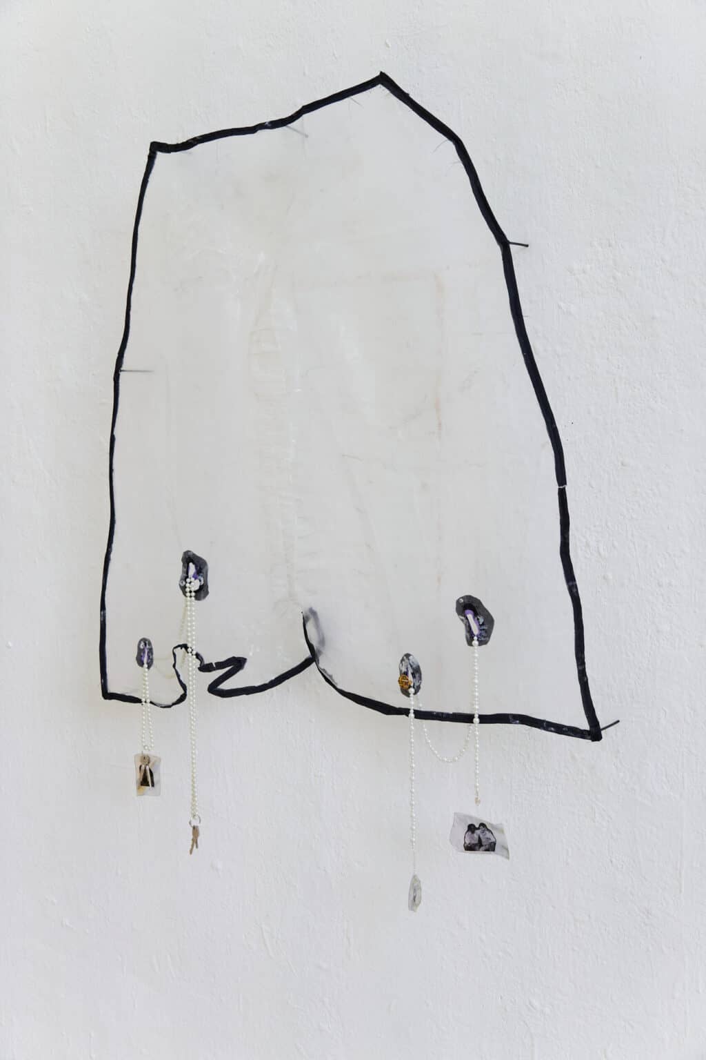 Foto: Nahaufnahme eines Objektes aus unterschiedlichen Materialien vor weißer Wand.