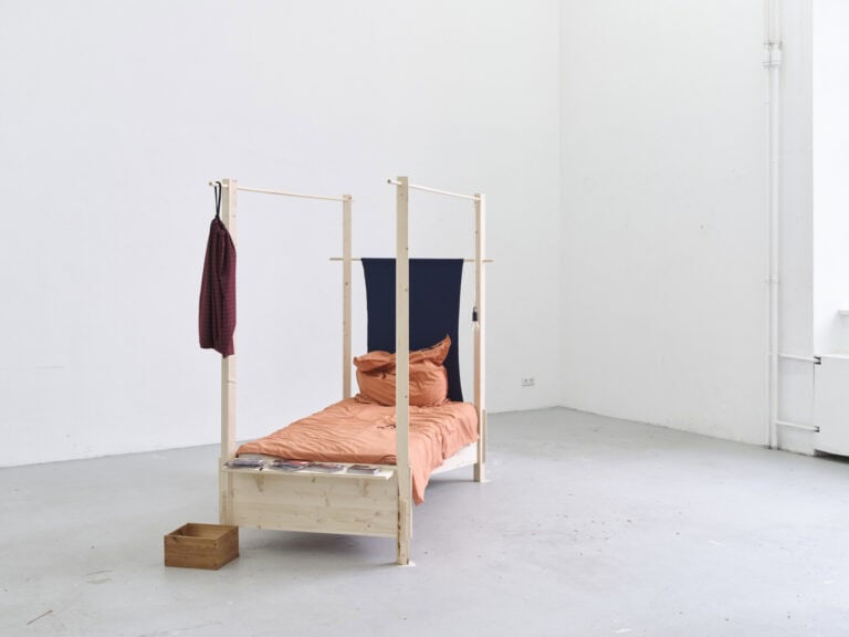 Foto: Aufnahme eines Raumes mit weißen Wänden und grauem Boden. Im Raum steht eine Skulptur auf dem Boden.