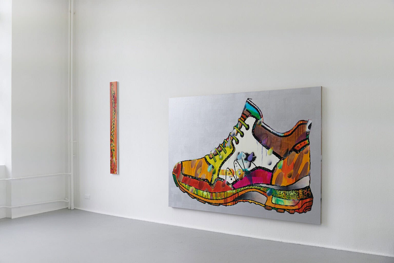 Foto: Ein Raum mit weißen Wänden und grauem Boden. An der Wand zwei Arbeiten auf Leinwand.