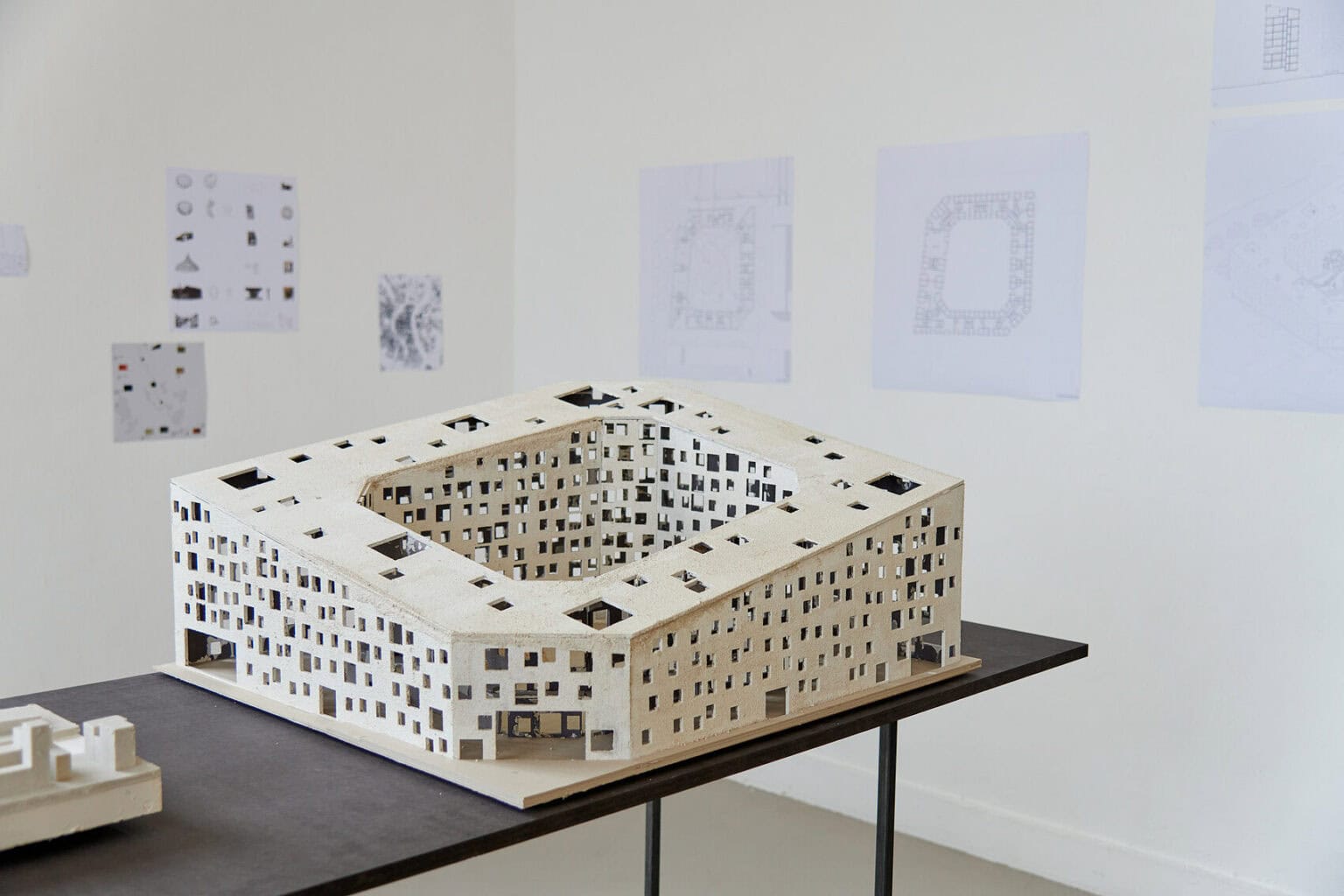 Foto: Architektonische Modelle aus unterschiedlichen Materialien auf einem schwarzen Tisch.