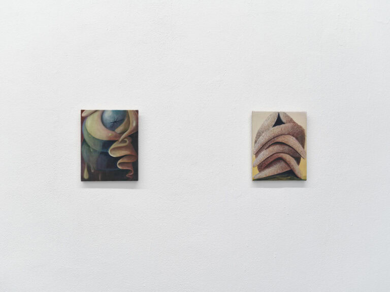 Foto: Eine weiße Wand mit zwei Malereien im gleichen Format, auch gleich Höhe.