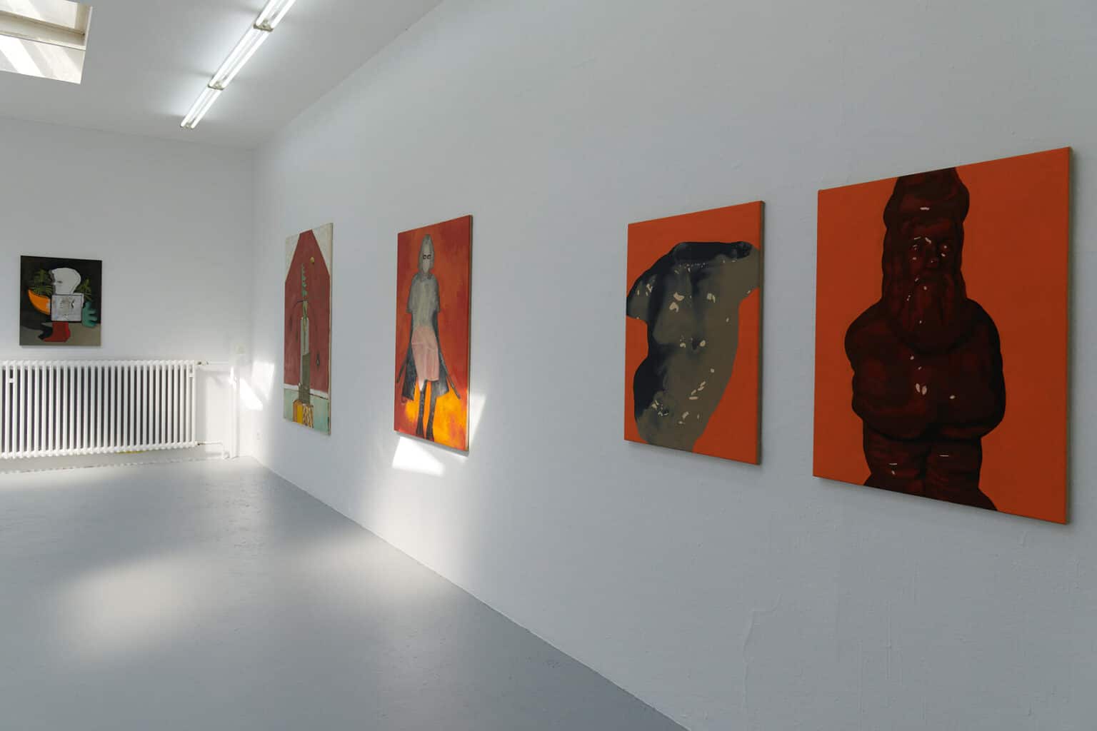 Foto: Ein Raum mit weißen Wänden und grauem Boden. An den Wänden hängen Leinwandarbeiten in Mittel- und Großformat.