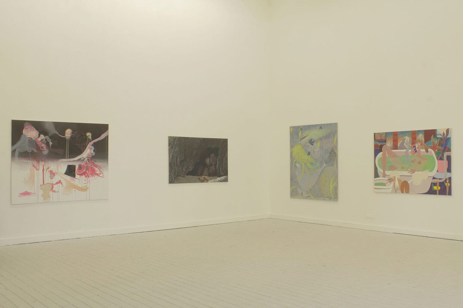 Foto: Ein Raum mit weißen Wänden und beigen Dielenboden. An der Wand befinden sich auf ähnlicher Höhe Malereien.