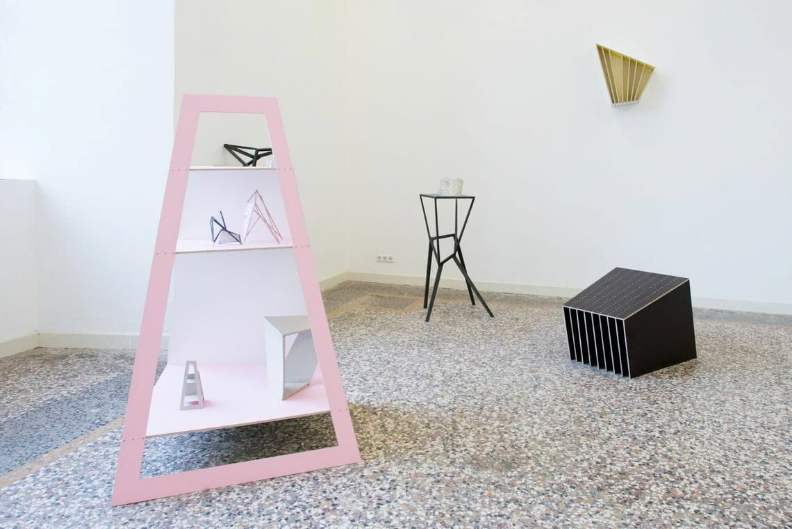 Foto: Ein Raum mit weißen Wänden und mehrfarbigem Steinboden. Im Raum und an der Wand befinden sich mehrere Objekte aus unterschiedlichen Materialien.