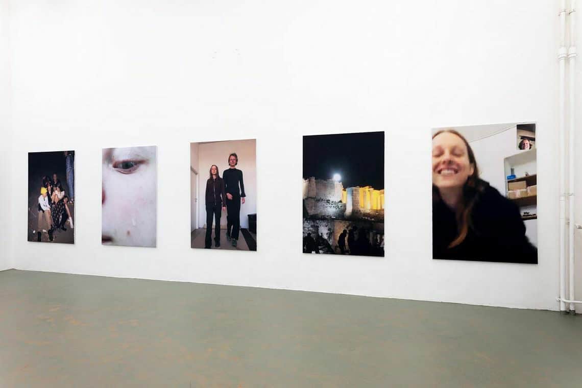 Foto: Ein Raum mit weißen Wänden und grauem Boden. An der Wand befinden sich fünf flache Objekte, in gleichem Format, auf gleicher Höhe und im gleichen Abstand zueinander hängend.