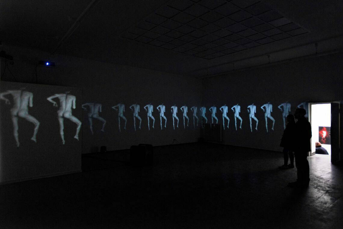 Foto: Ein dunkler Raum. Über die Wände des Raumes erstreckt sich eine Projektion.