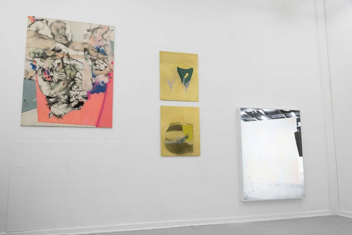 Foto: Ein Raum mit weißen Wänden und grauem Boden. An den Wänden hängen flache Objekte in großen Formaten.