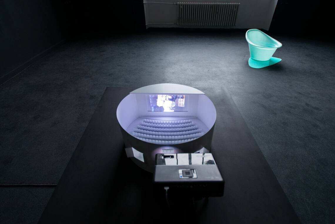 Foto: Ein Raum mit schwarzem Boden. Auf dem Boden stehen zwei farbige Objekte.