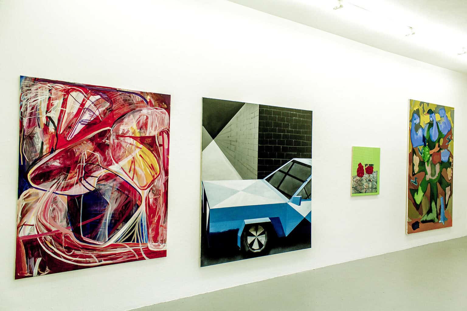 Foto: Ein Raum mit weißen Wänden und grauem Boden. An den Wänden befinden sich vier groß- und kleinformatige Leinwandarbeiten.